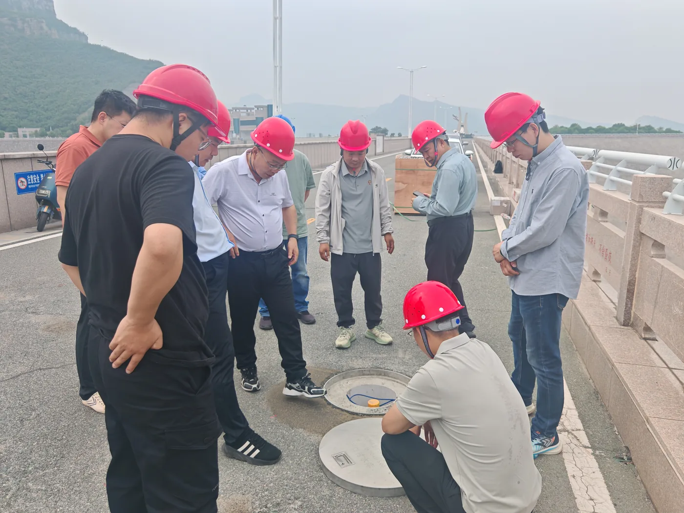 Technical staff inspecting a monitoring borehole at Hekoucun Reservoir